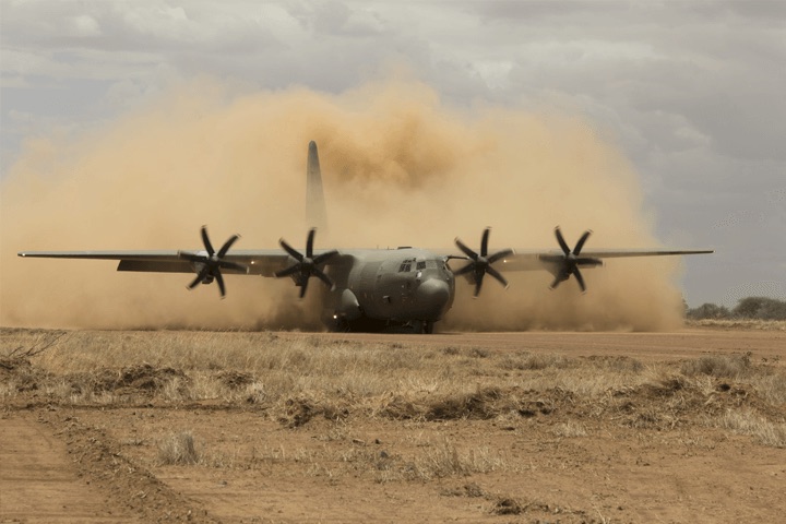 Military aircraft landing in a dust cloud